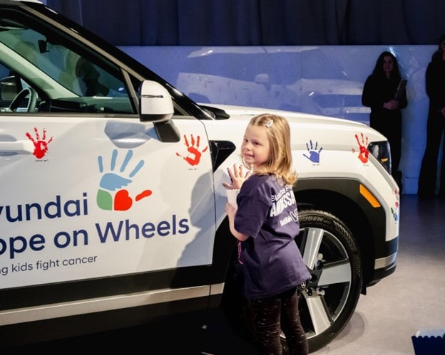Girl adds handprint to Hyundai Hope on Wheels car