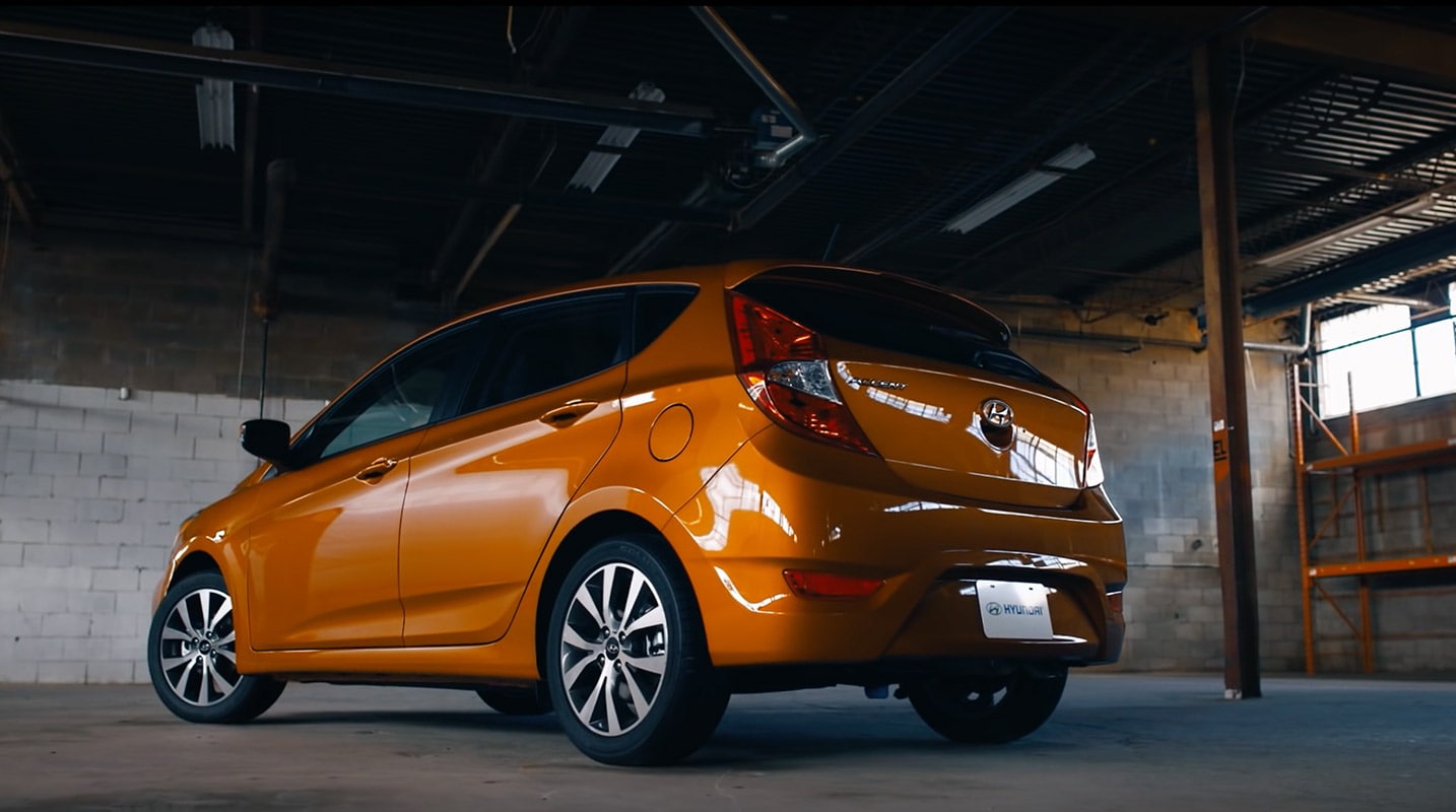 Vue latérale et arrière du grand hayon sur une vitamine C Orange 5 portes Hyundai Accent Sport Compact