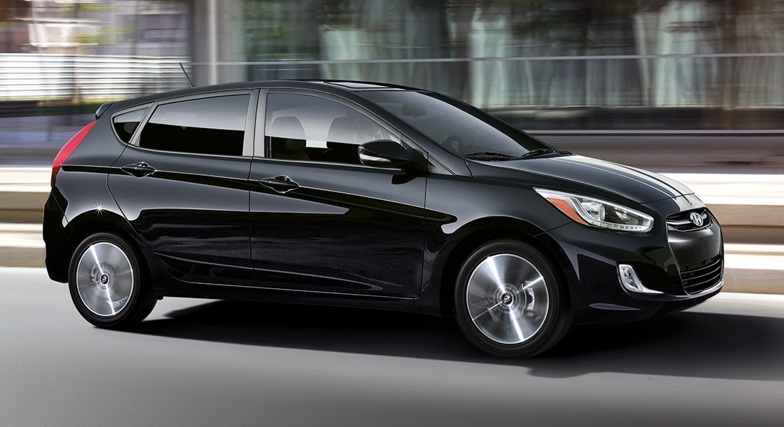 The exterior view in front of the Hyundai Accent compact black hatchback car with five doors