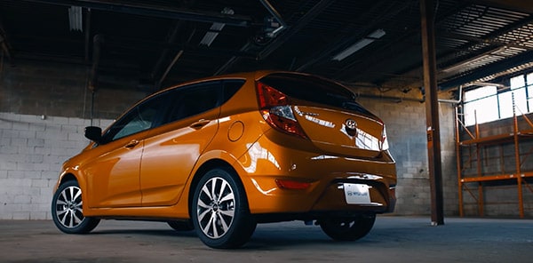 Side and Rear View Of The Large Hatchback On A Vitamin C Orange 5-Door Hyundai Accent Sport Compact  