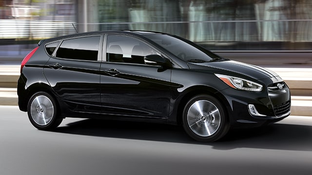 The exterior view in front of the Hyundai Accent compact black hatchback car with five doors