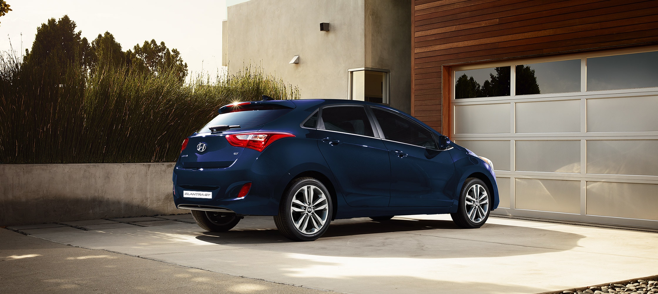 Exterior side image of blue Hyundai Elantra GT four door compact car with sleek LED tail lights