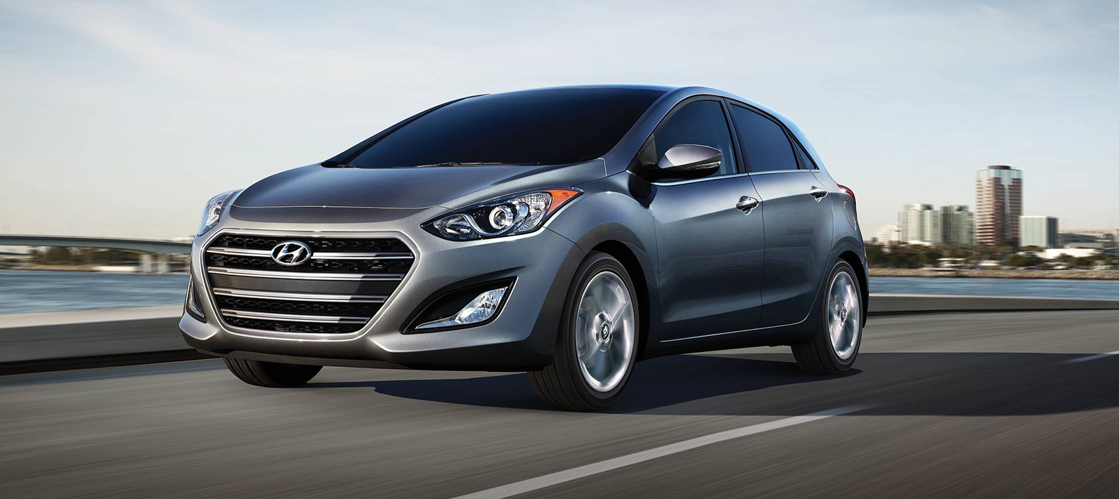 Exterior action photo of silver Hyundai Elantra GT four door compact car with signature hexagonal grille