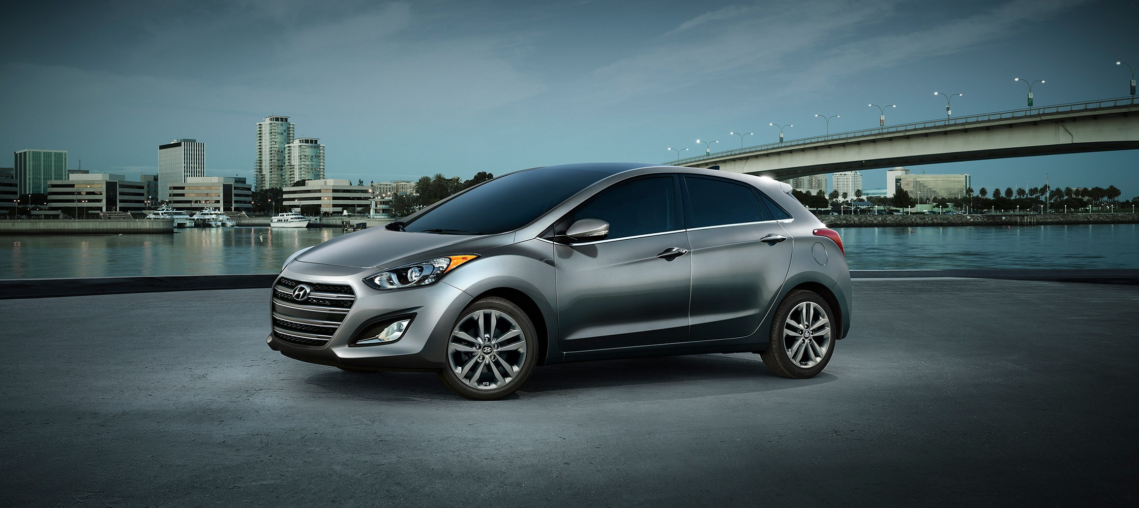 Exterior action photo of silver Hyundai Elantra GT four door compact car with signature hexagonal grille