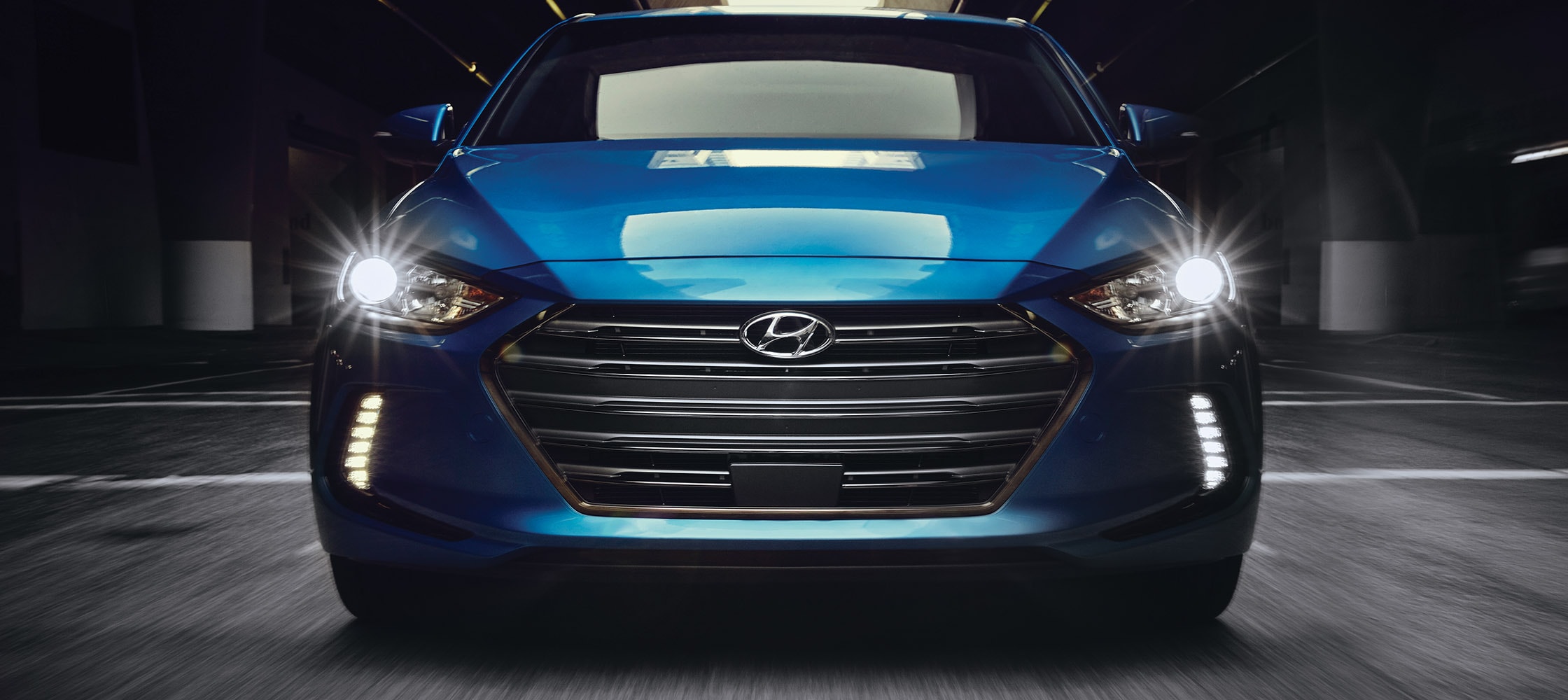 A jaw dropping view of the front LED headlights and running lights on the front of the Hyundai Elantra 2018 Shown Here In A Dark Warehouse