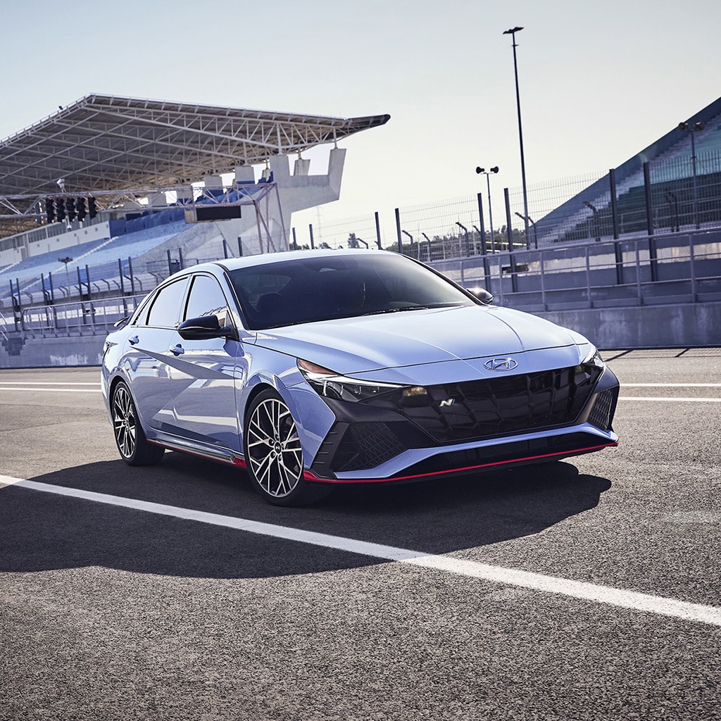 Front exterior view of a 2022 ELANTRA N in blue on a racetrack