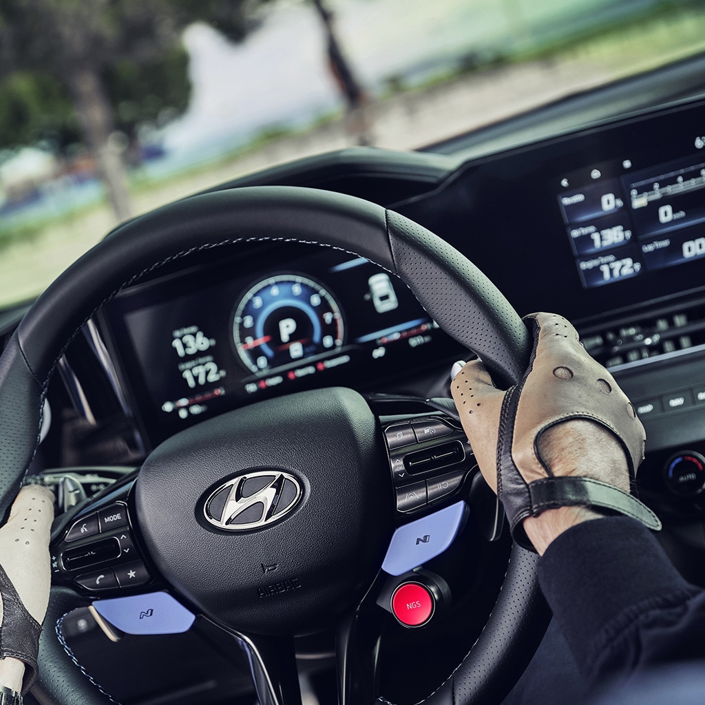 Person holding the leather-wrapped steering wheel in the 2022 ELANTRA N 
