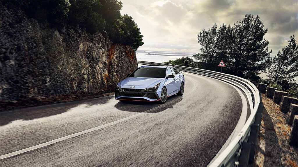 Vue avant de l'extérieur d'une ELANTRA N 2022 bleue en mouvement