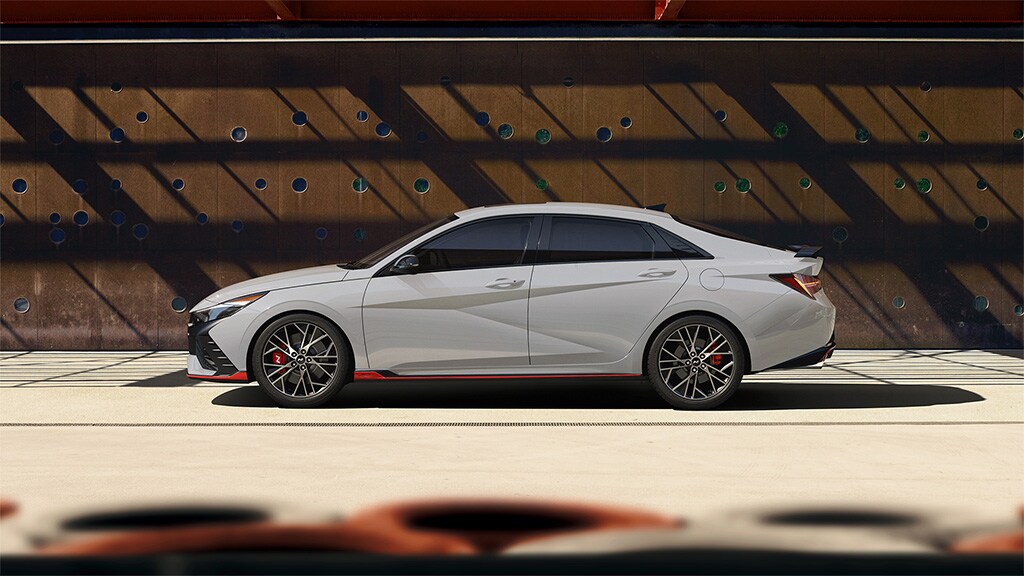 Vue latérale de l'extérieur d'une ELANTRA N 2022 blanche stationnée