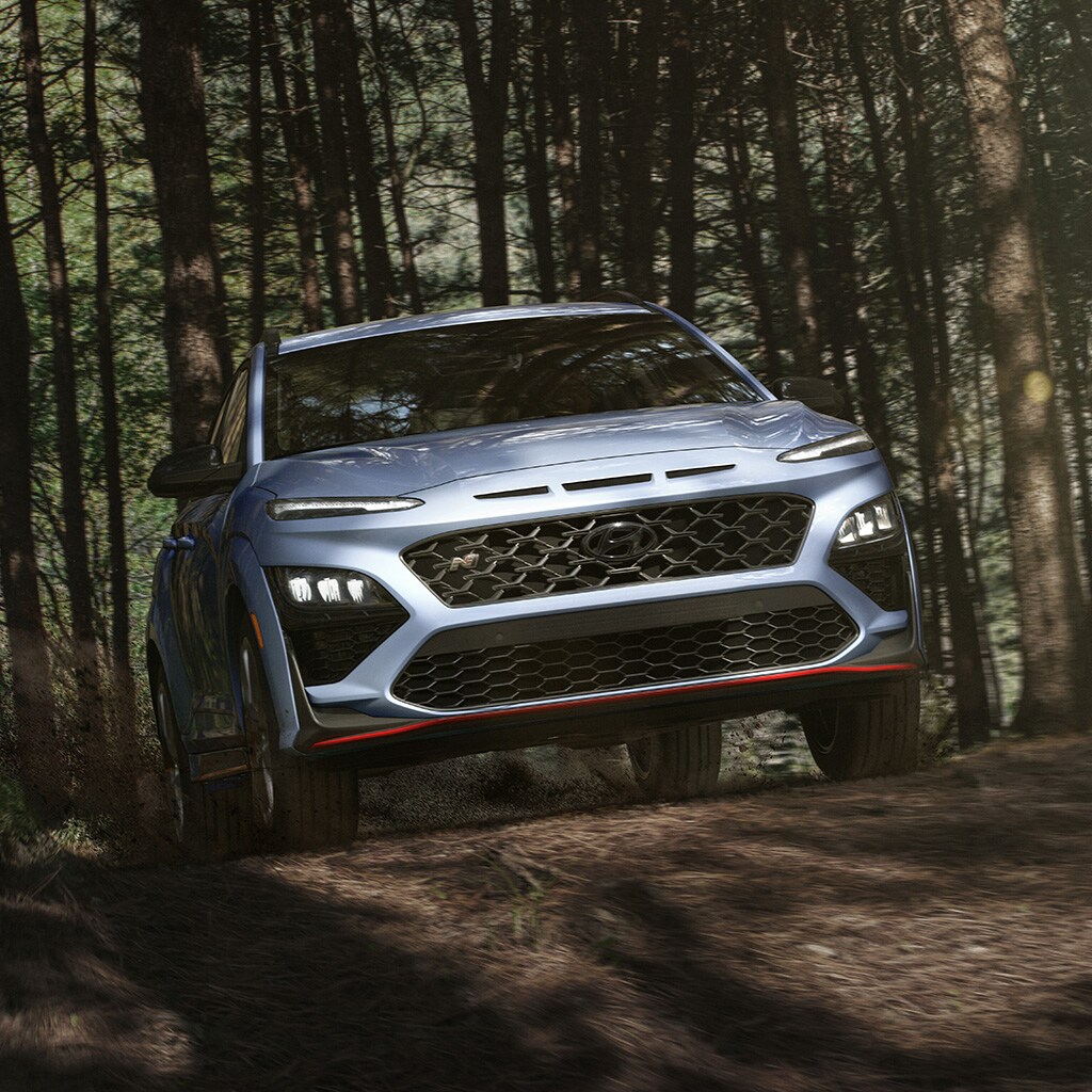 Vue avant d'un KONA N 2022 blanc sur une route en terre