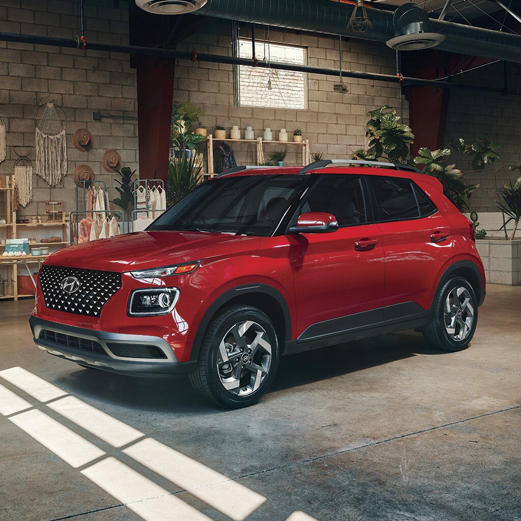 Vue de profil d'un VENUE 2022 rouge stationné